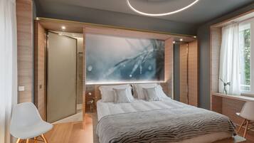 A modern bedroom with a large bed, a wall-mounted artwork, and a window with curtains.