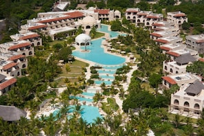 A resort with multiple swimming pools, palm trees, and Mediterranean-style architecture. - Swahili Beach Resort (Diani Beach)