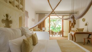 A hotel room with a large bed, a desk, and a view of the outdoors. - Swahili Beach Resort (Diani Beach)