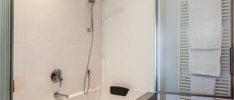 A modern bathroom with a glass shower enclosure, a bathtub, and a toilet.