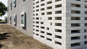 Ein modernes Gebäude mit einer Betonfassade und einer Reihe rechteckiger Fenster.