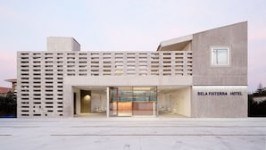 Ein modernes Hotel mit minimalistischem Design, das einen markanten Eingangsbereich und einen gut sichtbaren Empfang hat.
