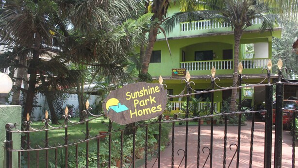 A gated entrance to Sunshine Park Homes with a sign indicating the name. - Sunshine Park Homes (Colva)