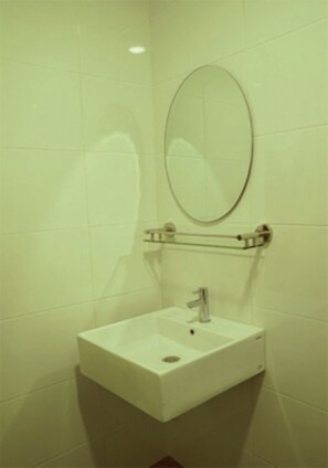 A bathroom with a white sink, a mirror, and a towel rack.