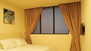 A bedroom with a bed, curtains, a wall-mounted TV, and a painting. - Charisma Hotel (Kuala Lumpur)
