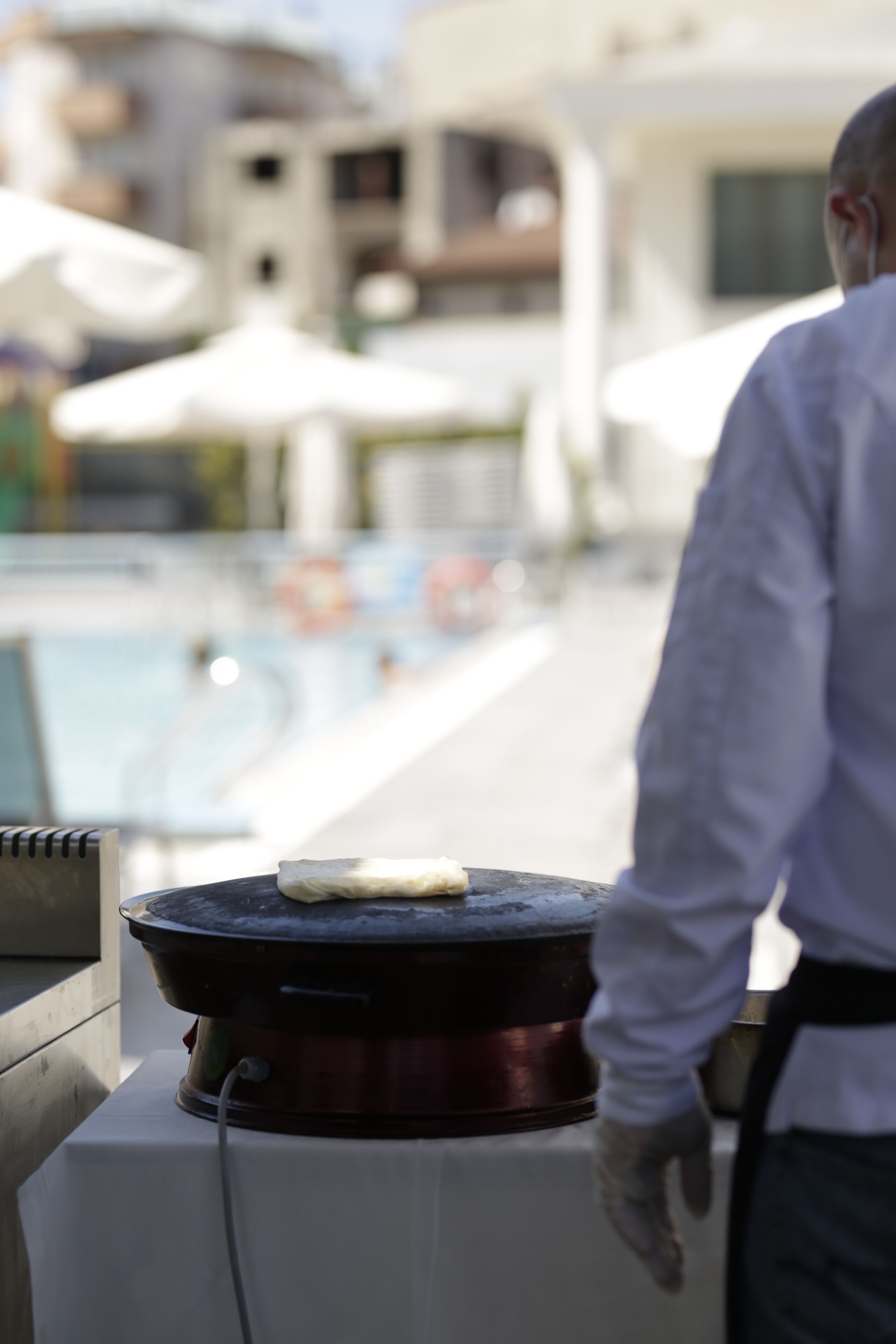 Jemand grillt draußen, im Hintergrund ist ein Pool zu sehen.