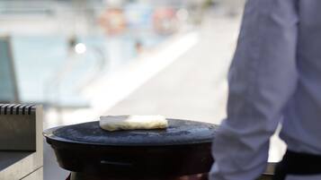 Jemand grillt draußen, im Hintergrund ist ein Pool zu sehen.