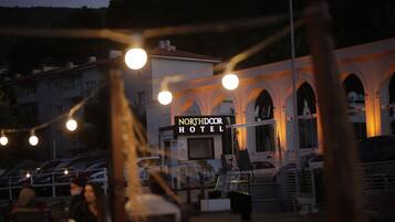 Hotel Northdoor con un letrero, zona de estar al aire libre y coches aparcados.