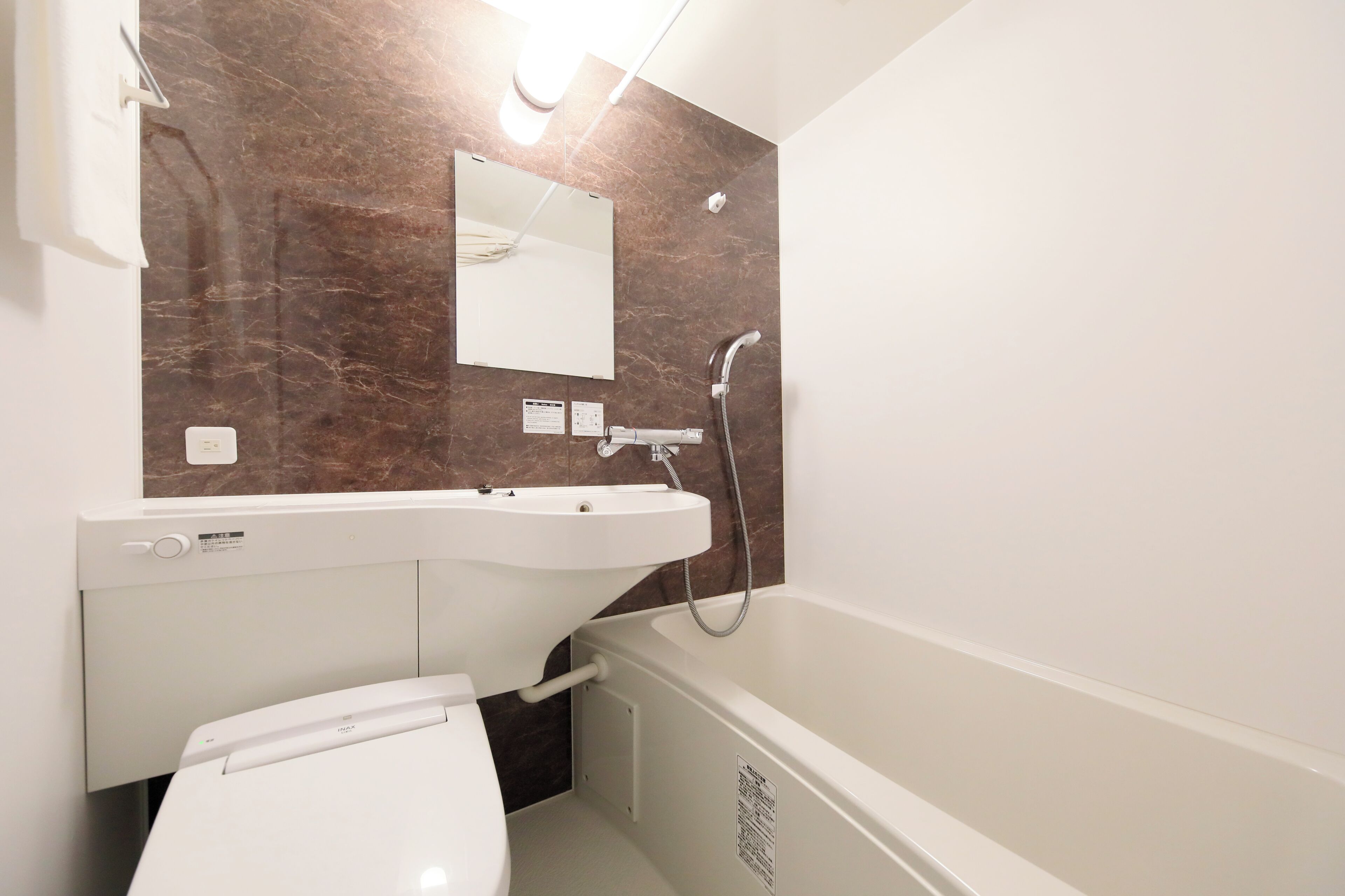 A bathroom with a white toilet, a sink, and a bathtub.