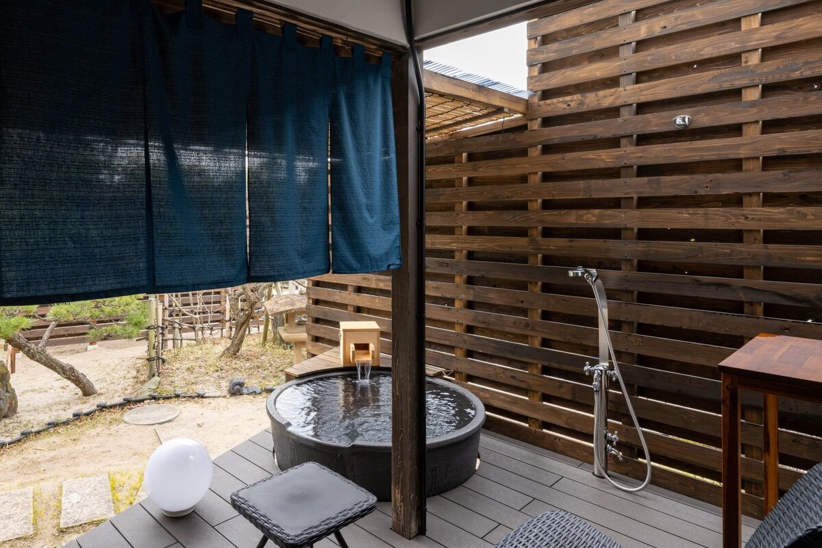 A wooden deck with a hot tub, a small table, and a chair.