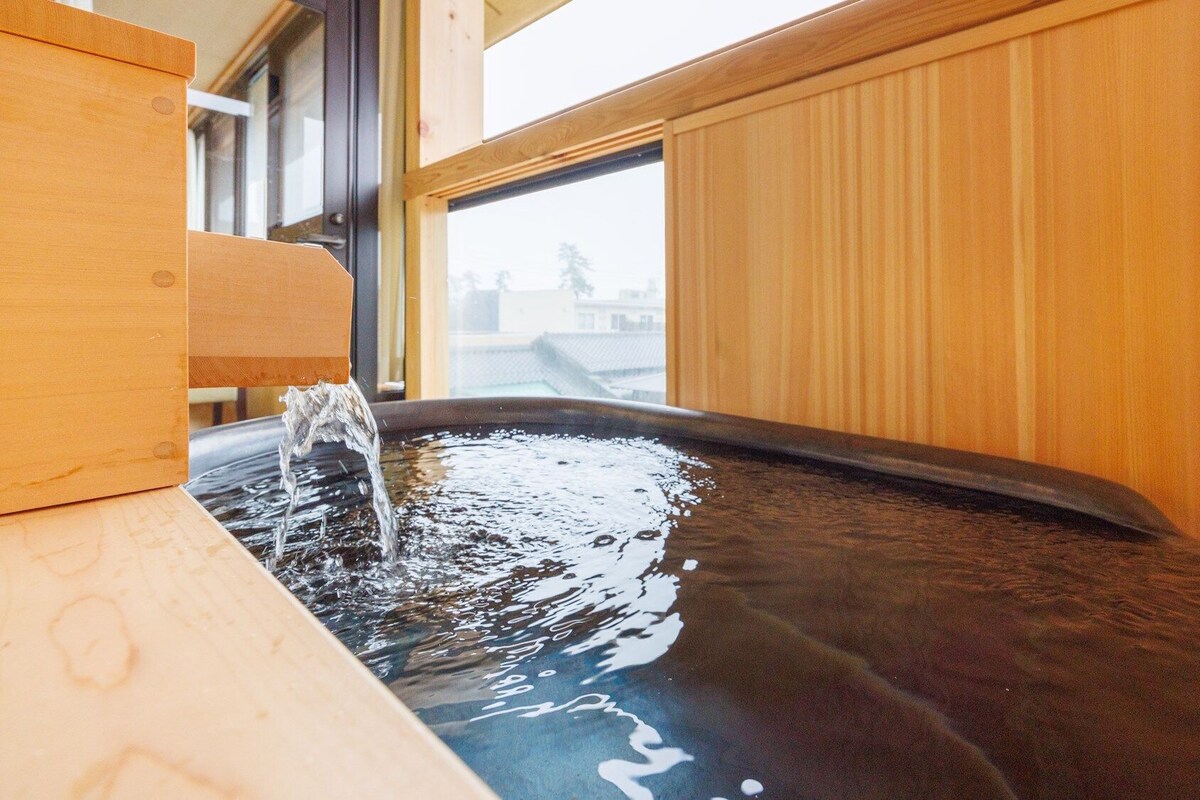 A hot spring bath with wooden walls and a window.