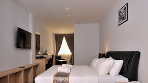 Una camera d'albergo con un letto, comodino, scrivania, sedia e televisore.