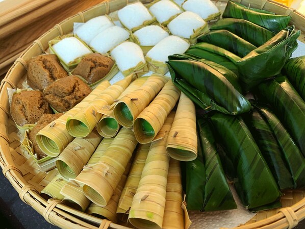 Una cesta con diversos alimentos tradicionales envueltos en hojas.