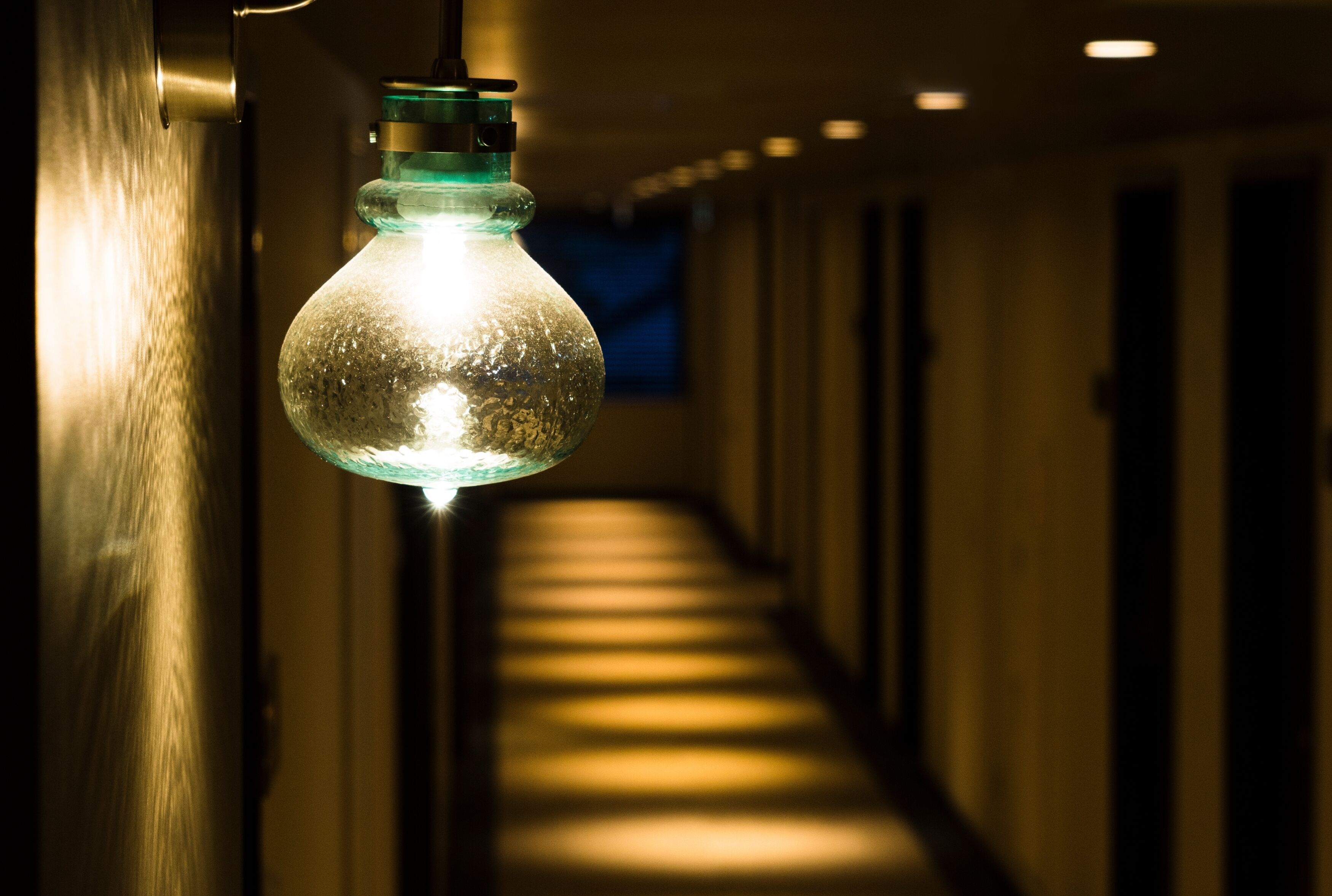 A hallway with a hanging light fixture.