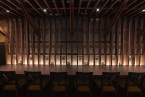 A conference room with a long table and chairs, wooden beams on the ceiling, and a patterned wall. - Hotel Torifito Otaru Canal (Otaru)