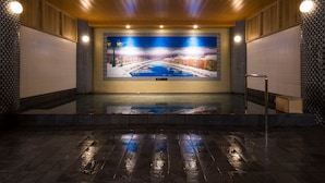 Uma área ampla de piscina interna com um grande mural retratando uma paisagem nevada de vila.