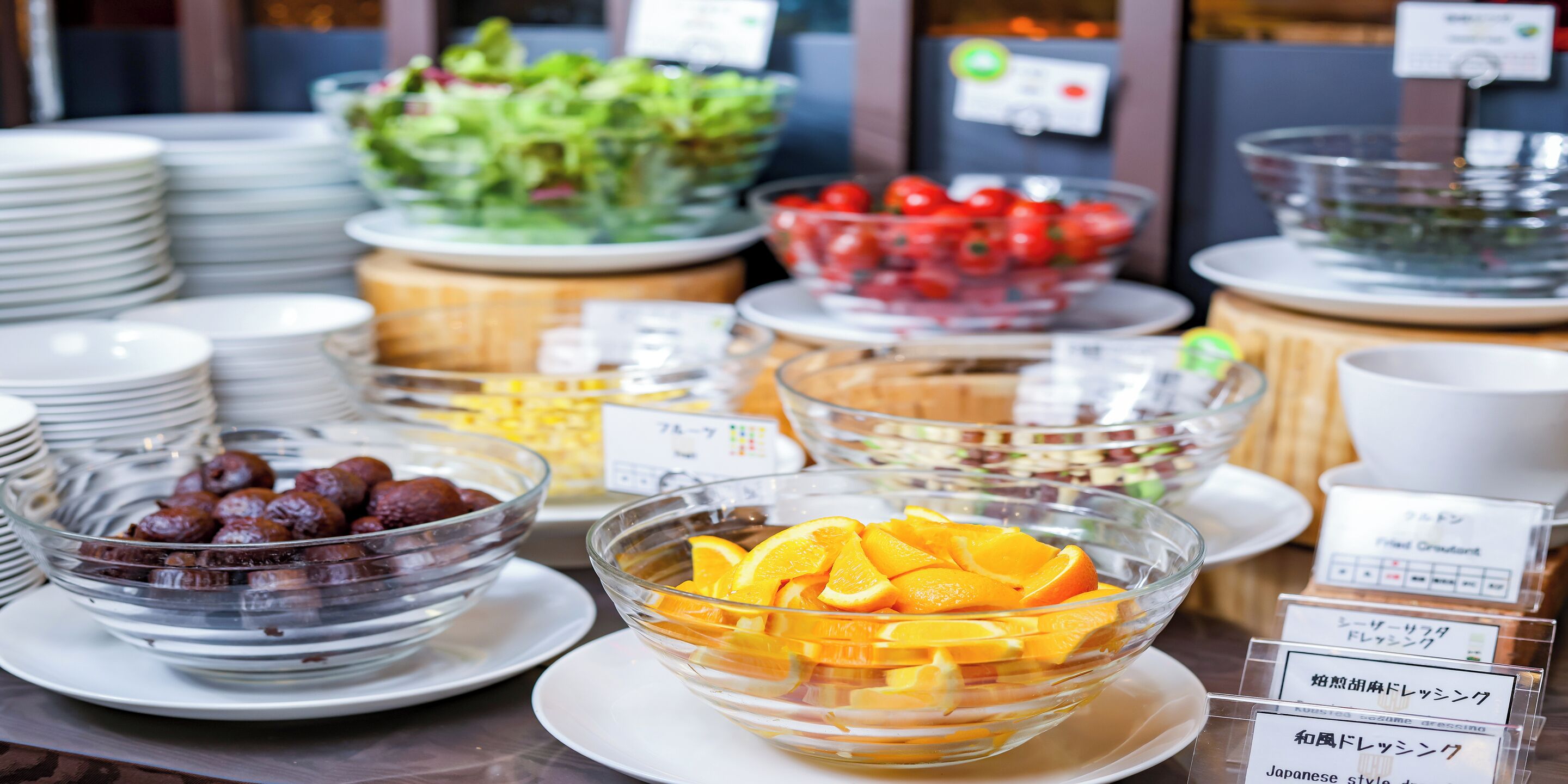 Un bufé con diferentes platillos, incluyendo frutas y ensaladas.