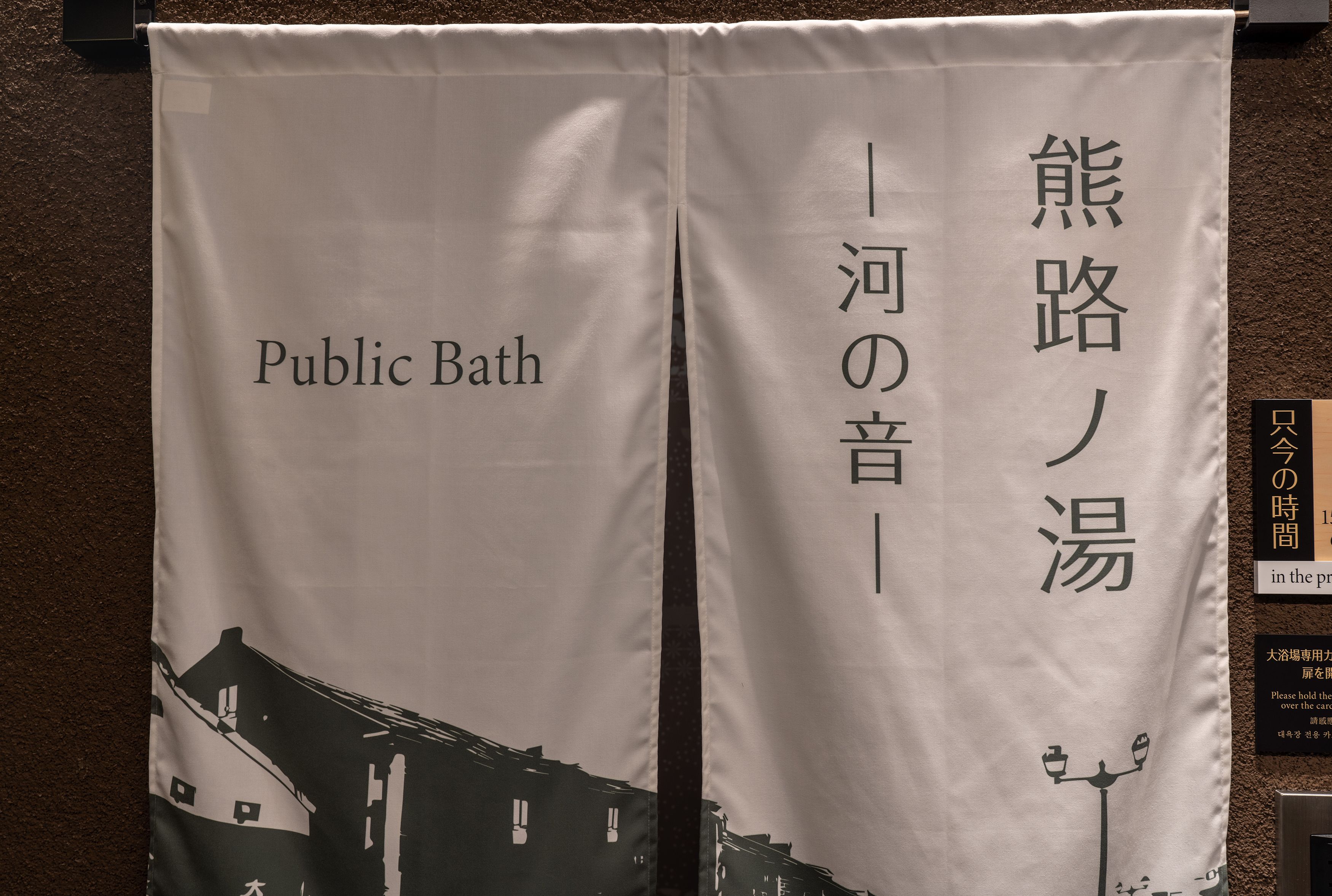 A banner with the text "Public Bath" and "熊路の湯" in English and Japanese, respectively.