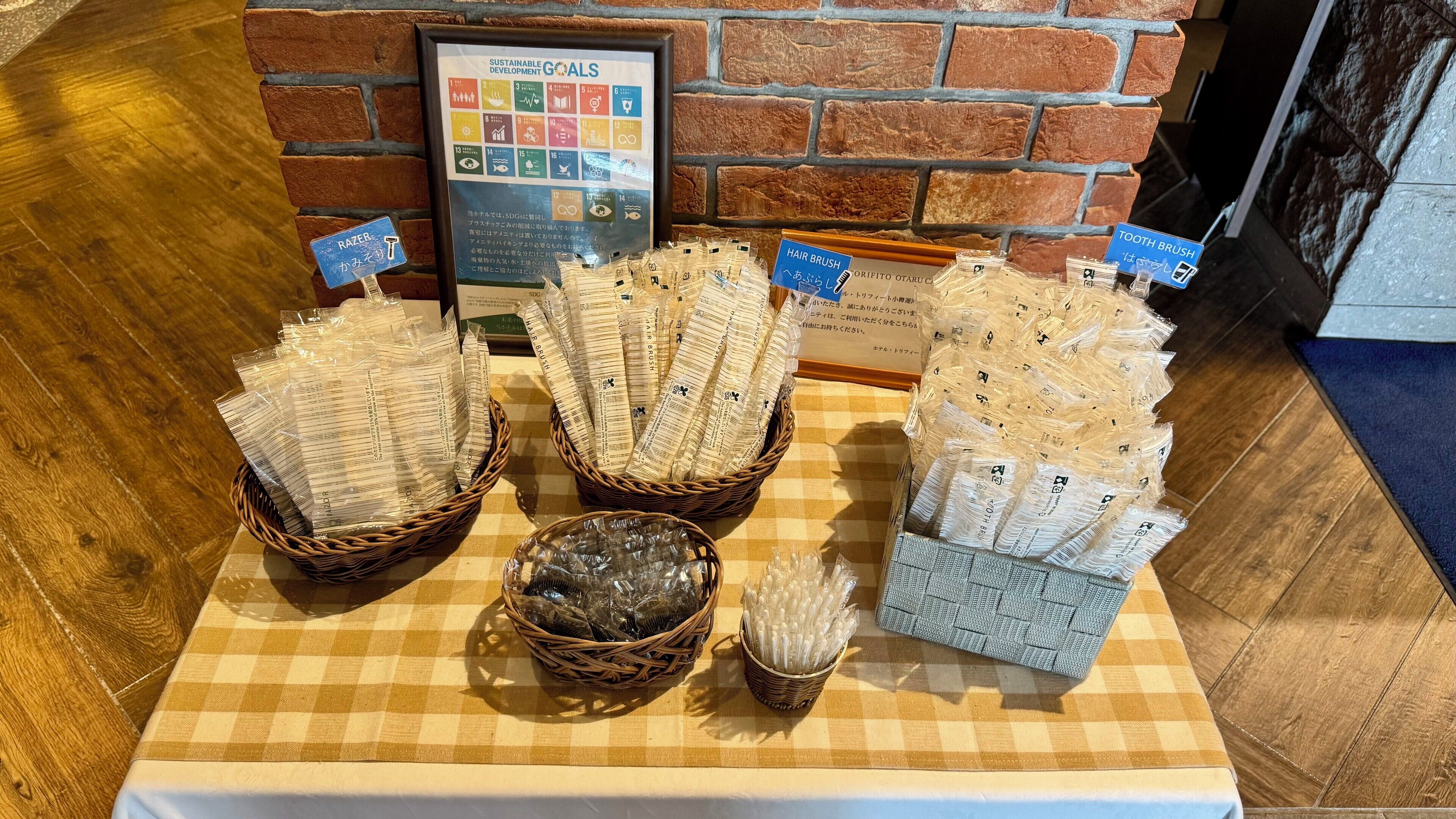 Pöydällä on esillä erilaisia hiusharjoja ja -kammoja, ja taustalla näkyy tiiliseinä.