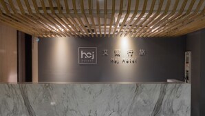 A reception desk with a marble top and a wooden ceiling structure. - Hej Taipei (Taipei)