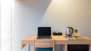 A modern workspace with a laptop on a wooden desk, a kettle, and a glass partition. - Hej Taipei (Taipei)
