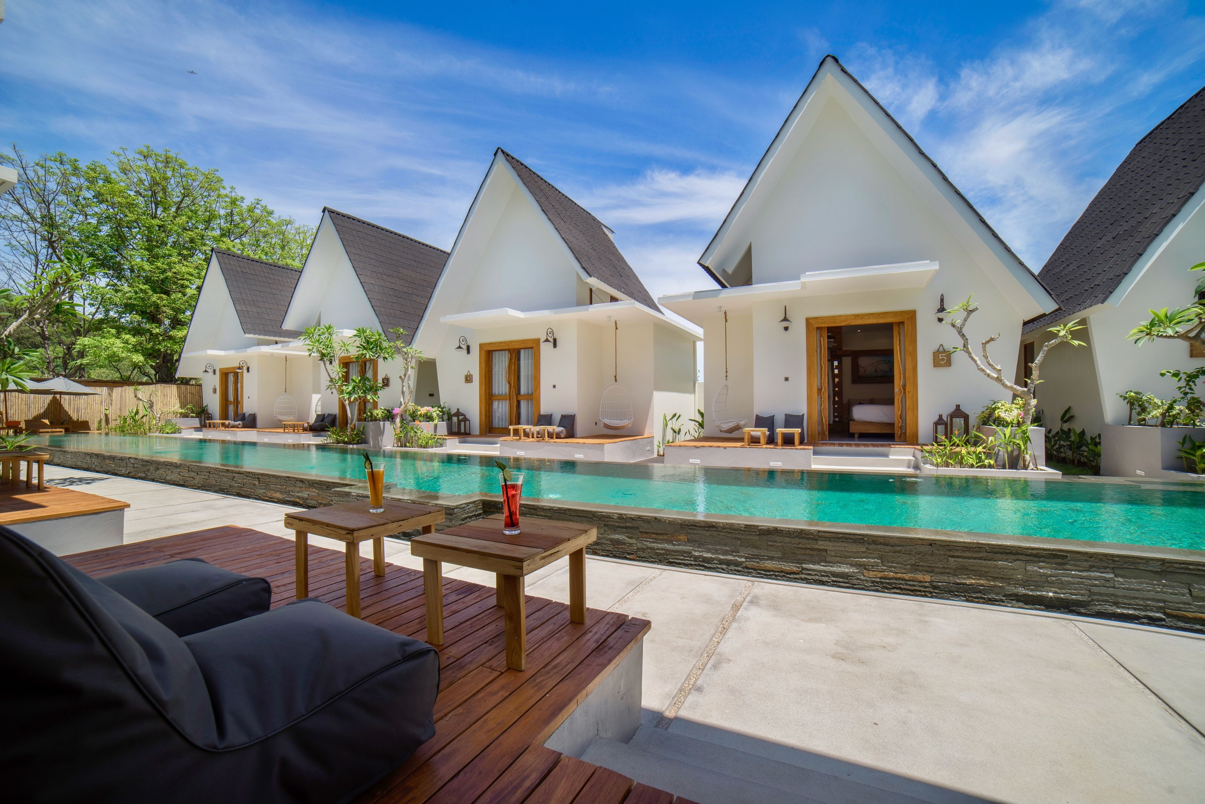 A resort with multiple bungalow-style accommodations, a central swimming pool, and outdoor seating areas.