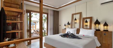 A modern hotel room with a wooden bed frame, a desk with a laptop, and a view of the outdoors.