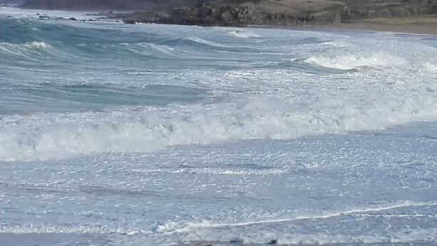 A beach with waves crashing onto the shore.