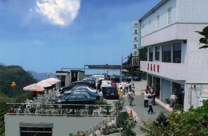 Un hôtel à l’extérieur revêtu de carreaux, doté d’un espace extérieur couvert aménagé en coin salon et offrant une vue sur le paysage environnant.
