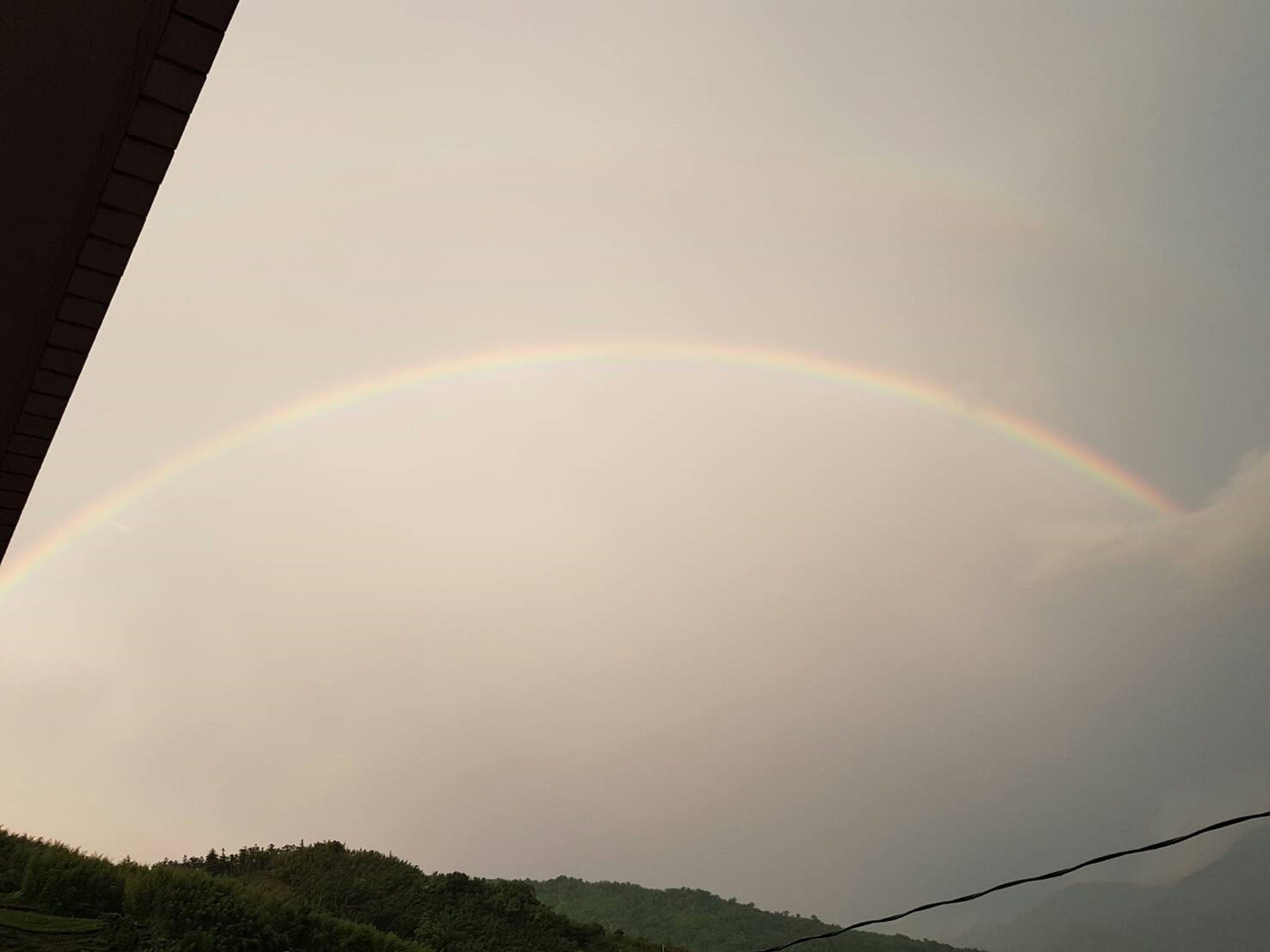 Un paisaje con un arcoíris que se extiende por el cielo.