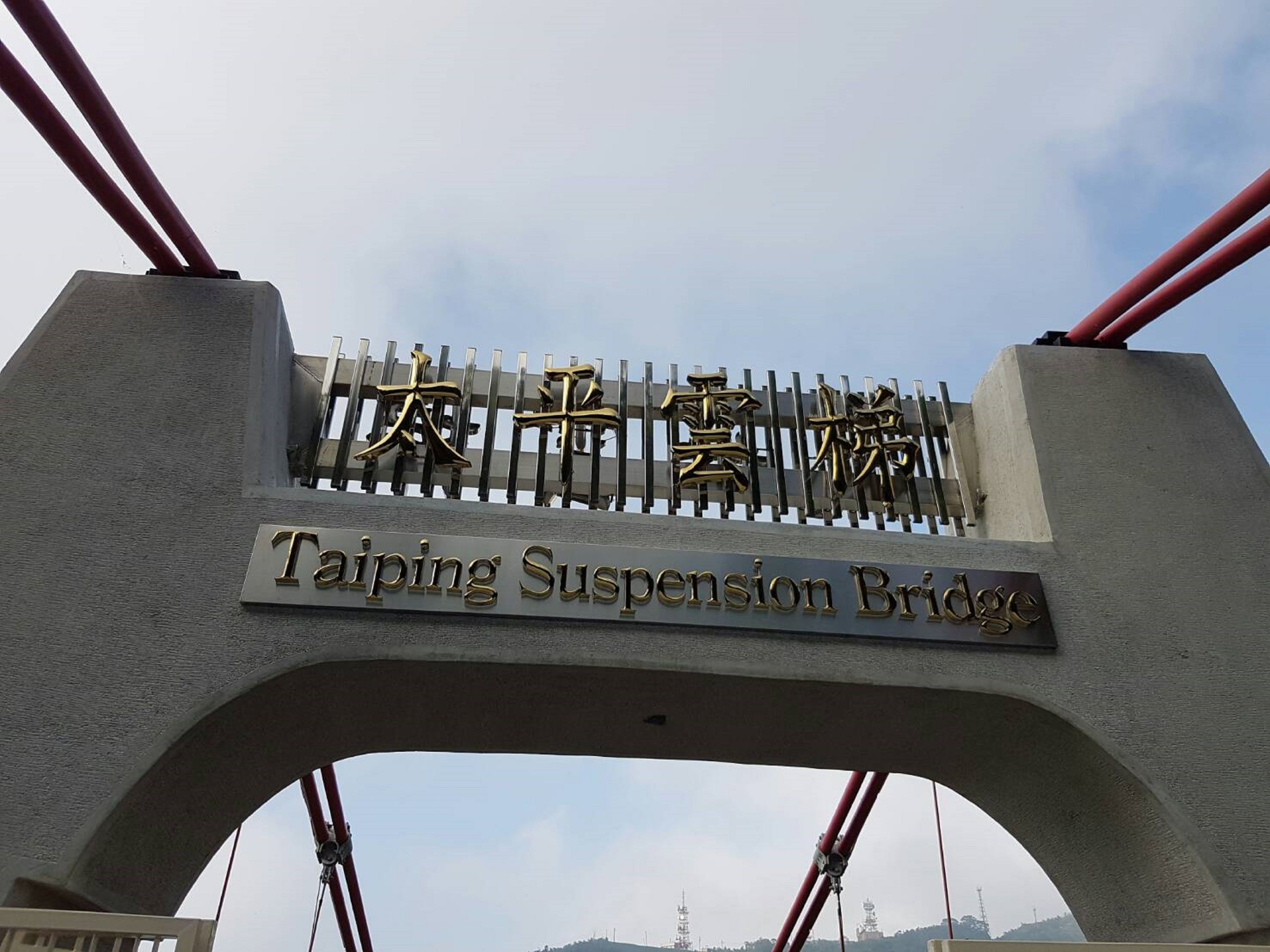 A bridge with a sign reading "Taiping Suspension Bridge" in both English and Chinese.