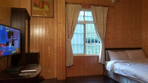 A room with wooden walls, a bed, a TV on a stand, and a window with curtains. - Ming Yang B&B (Zhuqi)