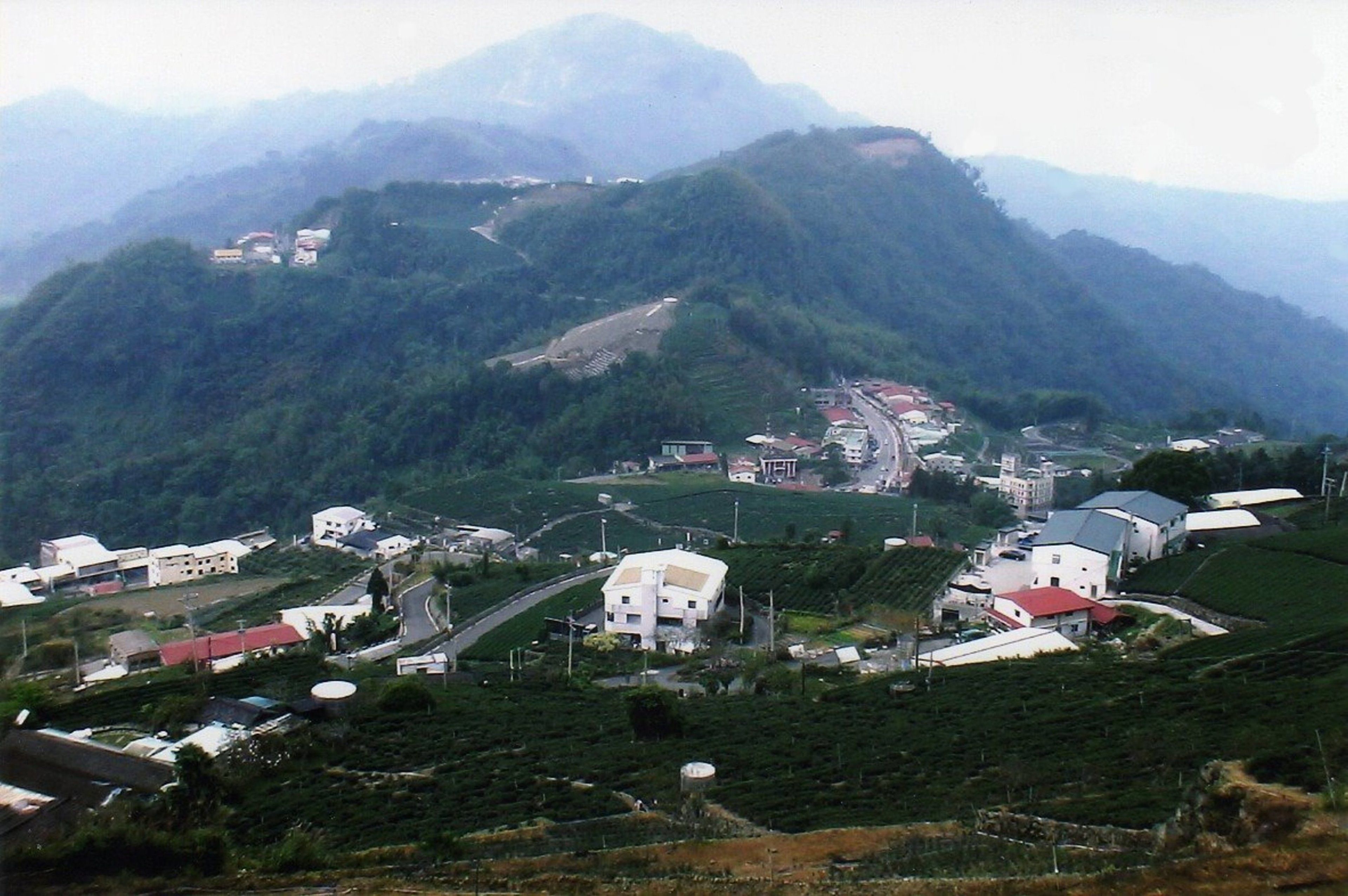 Un pueblo montañoso con edificios y caminos.