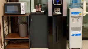 A kitchenette with a microwave, coffee machine, and water dispenser. - Hotel Ascent Hamamatsu (Hamamatsu)