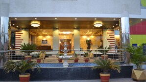 A hotel entrance with a fountain, potted plants, and a reception area. - 5 Flowers Ananta Elite, Kota (Kota)