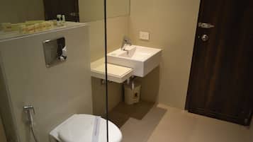 Un baño moderno con inodoro, lavamanos y ducha.