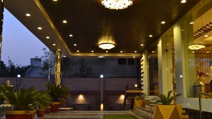 An indoor area with a ceiling adorned with multiple lights, potted plants, and a staircase leading to an upper level. - 5 Flowers Ananta Elite, Kota (Kota)