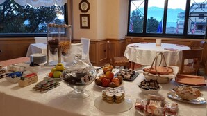 Ein Buffet mit verschiedenen Speisen, einer Obstschale und einem Glas mit Nüssen.
