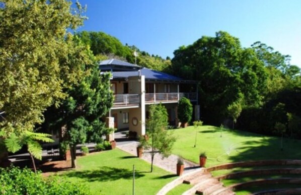 A two-story house with a balcony, surrounded by lush greenery and a well-maintained lawn. - Willows Boutique Hotel (Pretoria)