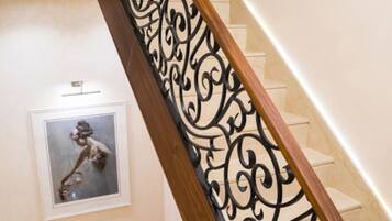 A staircase with a wooden handrail and decorative metal balustrade.
