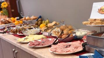 Een buffet met diverse soorten eten, zoals brood, gebak en vlees.