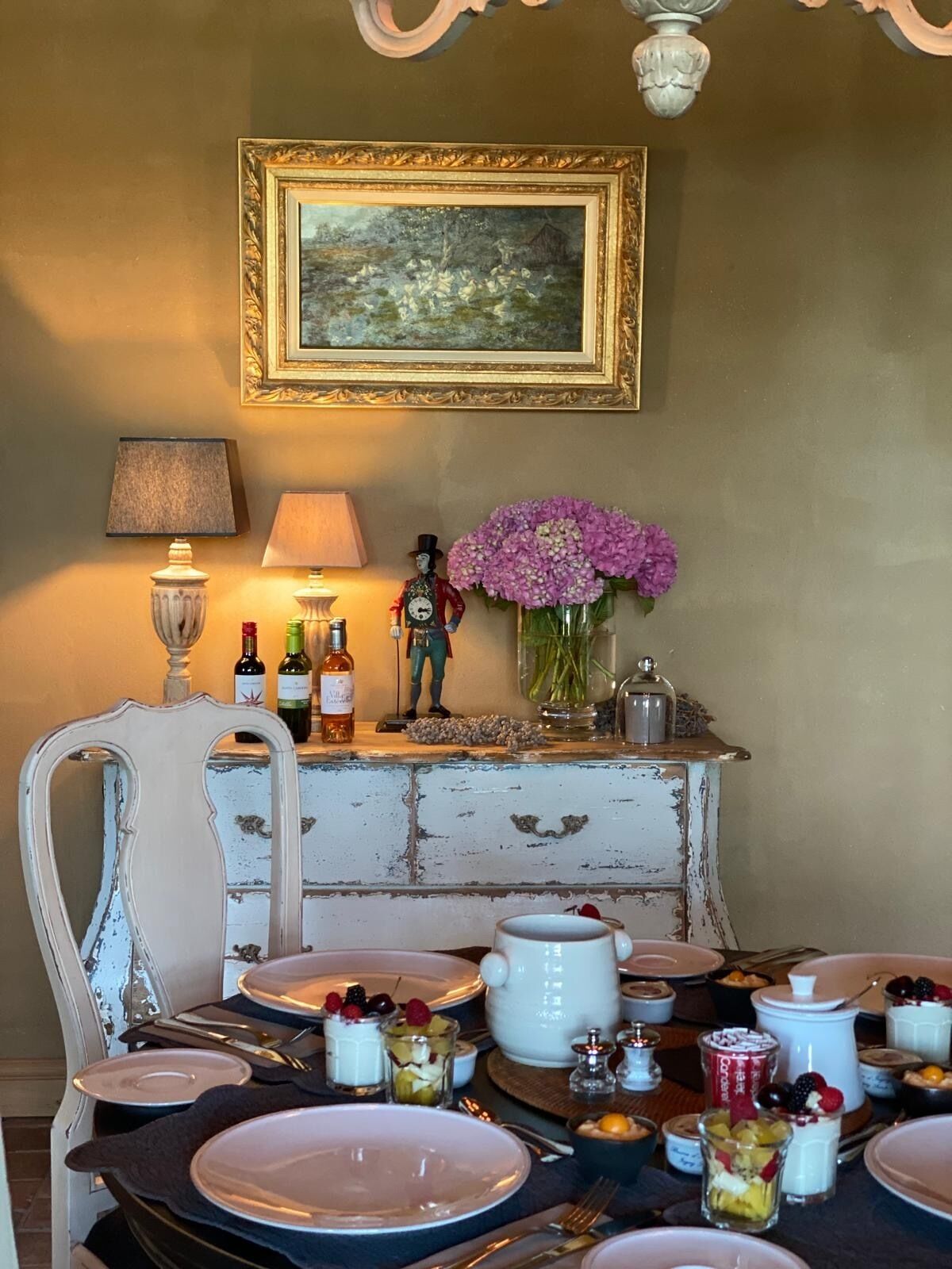 A dining table set with plates, cutlery, and a variety of desserts.
