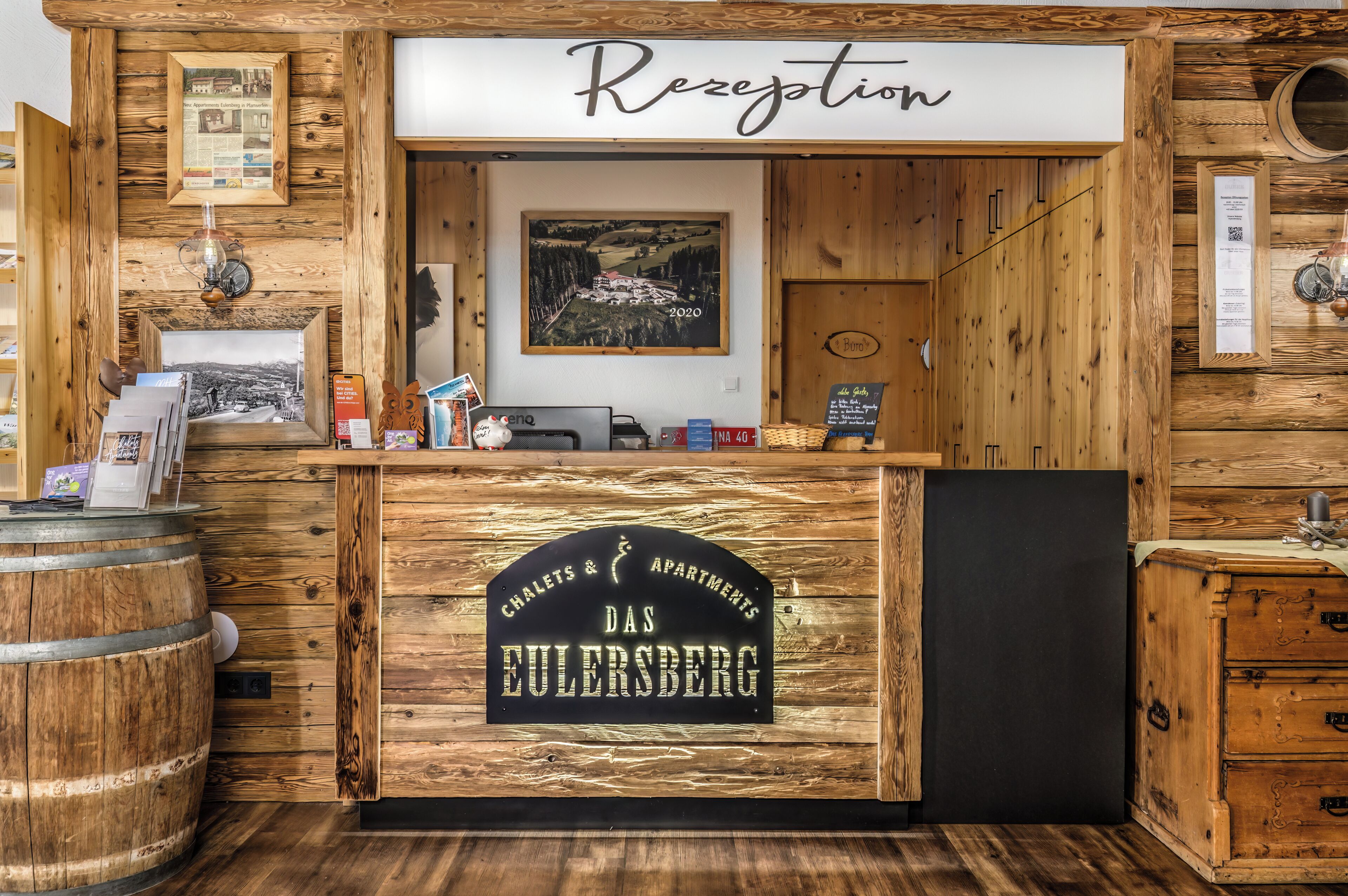 A reception desk with a sign reading "Das Eulersberg" and "Chalet & Apartments".