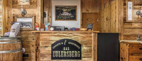 A reception desk with a sign reading "Das Eulersberg" and "Chalet & Apartments".