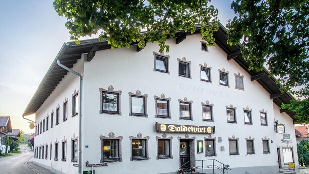 Un edificio tradicional con un cartel que dice "GASTHOF Pension" y "Dolderwirt".