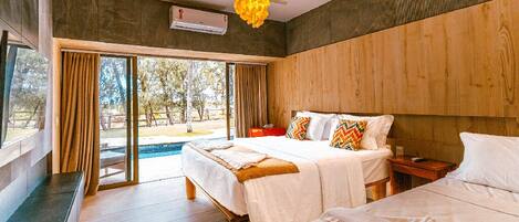 A modern bedroom with two beds, a wooden headboard, a large window with curtains, and a ceiling fan.