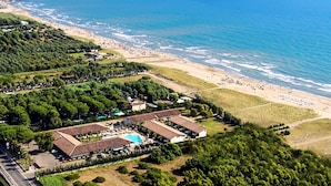 An aerial view of a coastal resort with multiple buildings, a swimming pool, and a beach. - Paestum Inn Beach Resort (Capaccio-Paestum)