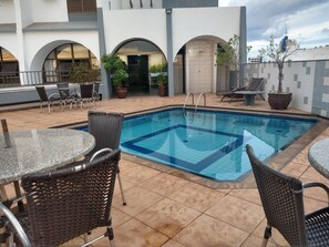 حمّام سباحة خارجي، مظلات على حمّام السباحة، مقاعد للتشمس