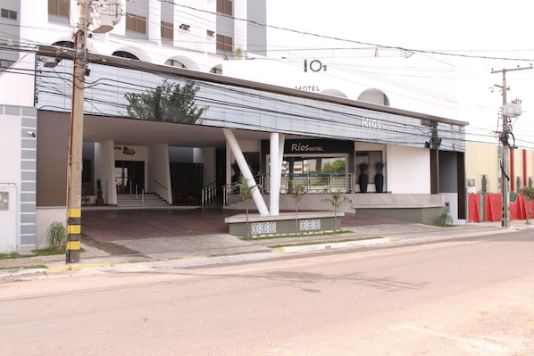 A hotel with a modern facade, a covered entrance, and a visible staircase leading to the entrance.