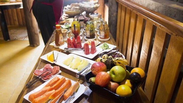 Een buffet met diverse gerechten, waaronder fruit, groenten en vlees.